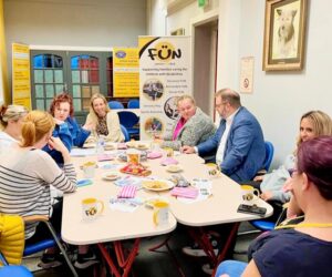 parents sat round a table with a families united charity banner displayed whilst parents discuss topical issues with a local Cllr and MP